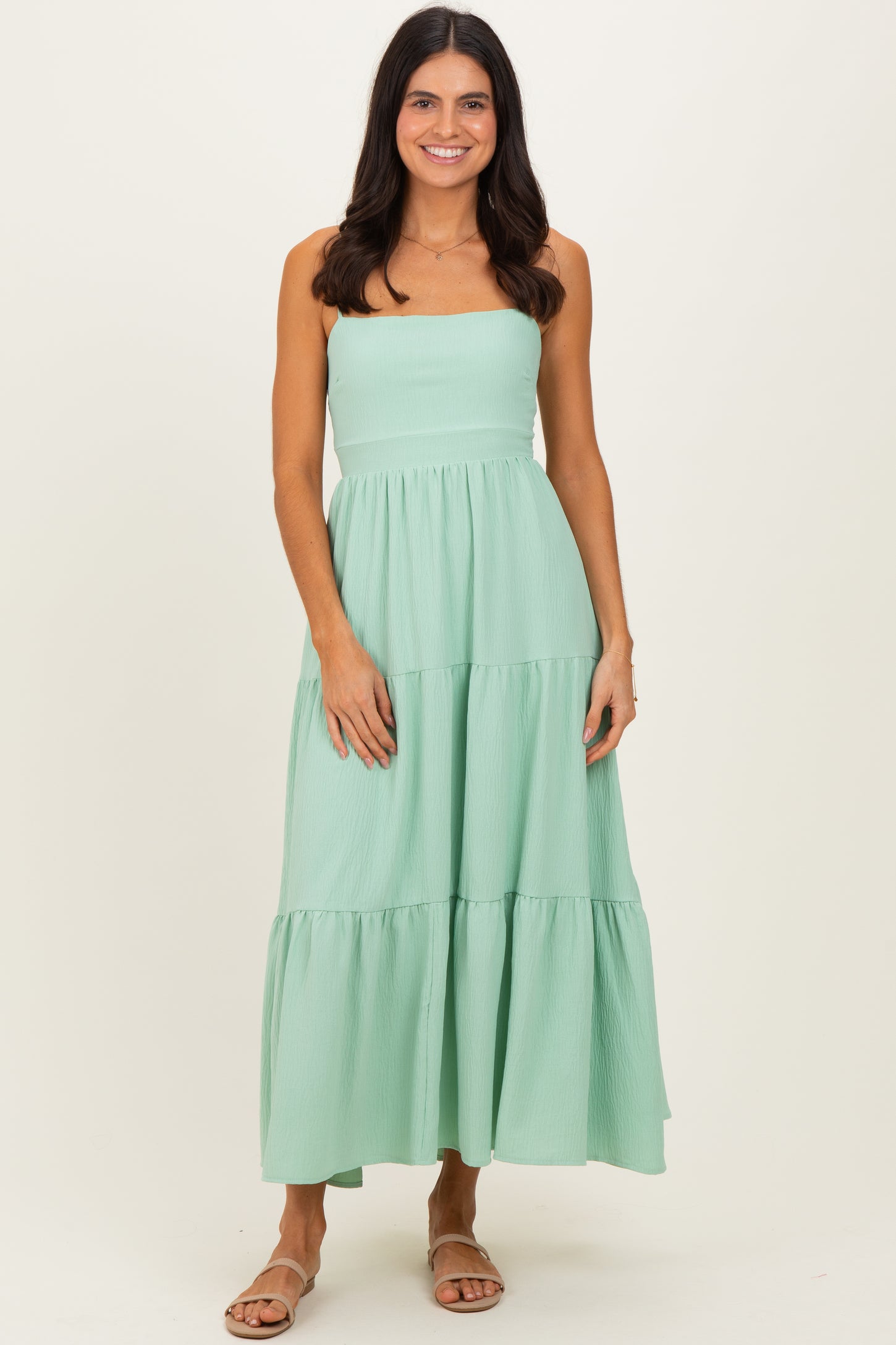 woman wearing a mint green strapless tiered maxi dress with a flowy silhouette