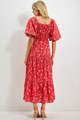 woman wearing a red floral maxi dress with puff sleeves and a tiered skirt, viewed from the back