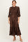 woman wearing a brown pleated midi dress with a smocked bodice and three-quarter sleeves