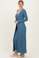 woman wearing a blue ribbed long sleeve dress with a deep neckline and side slits