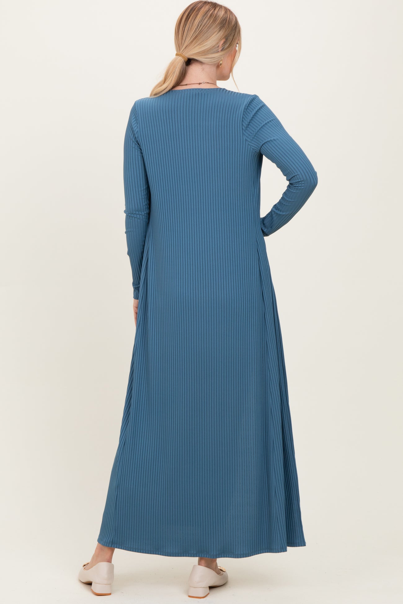 woman wearing a long sleeve ribbed maxi dress in blue, shown from the back