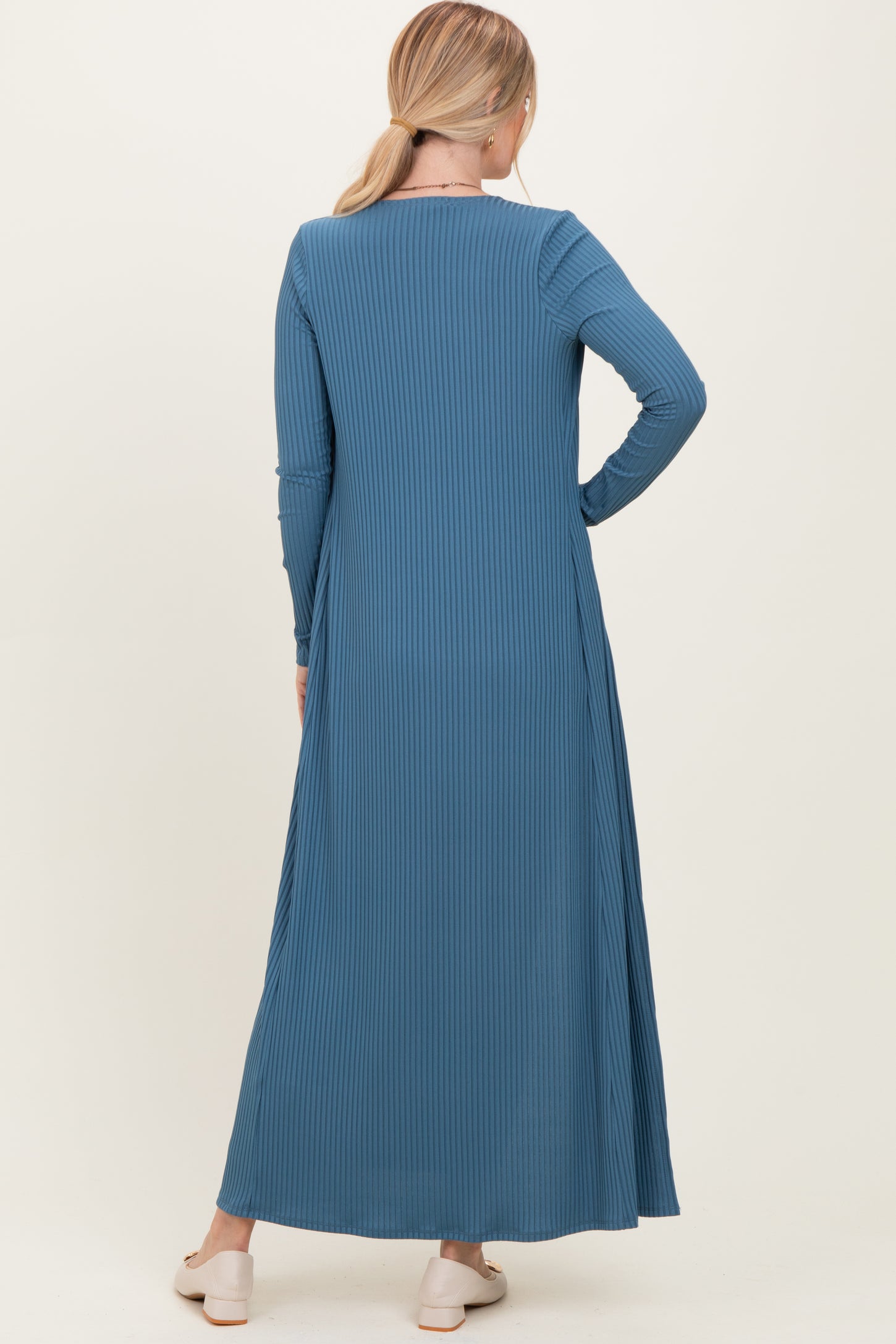 woman wearing a long sleeve ribbed maxi dress in blue, shown from the back