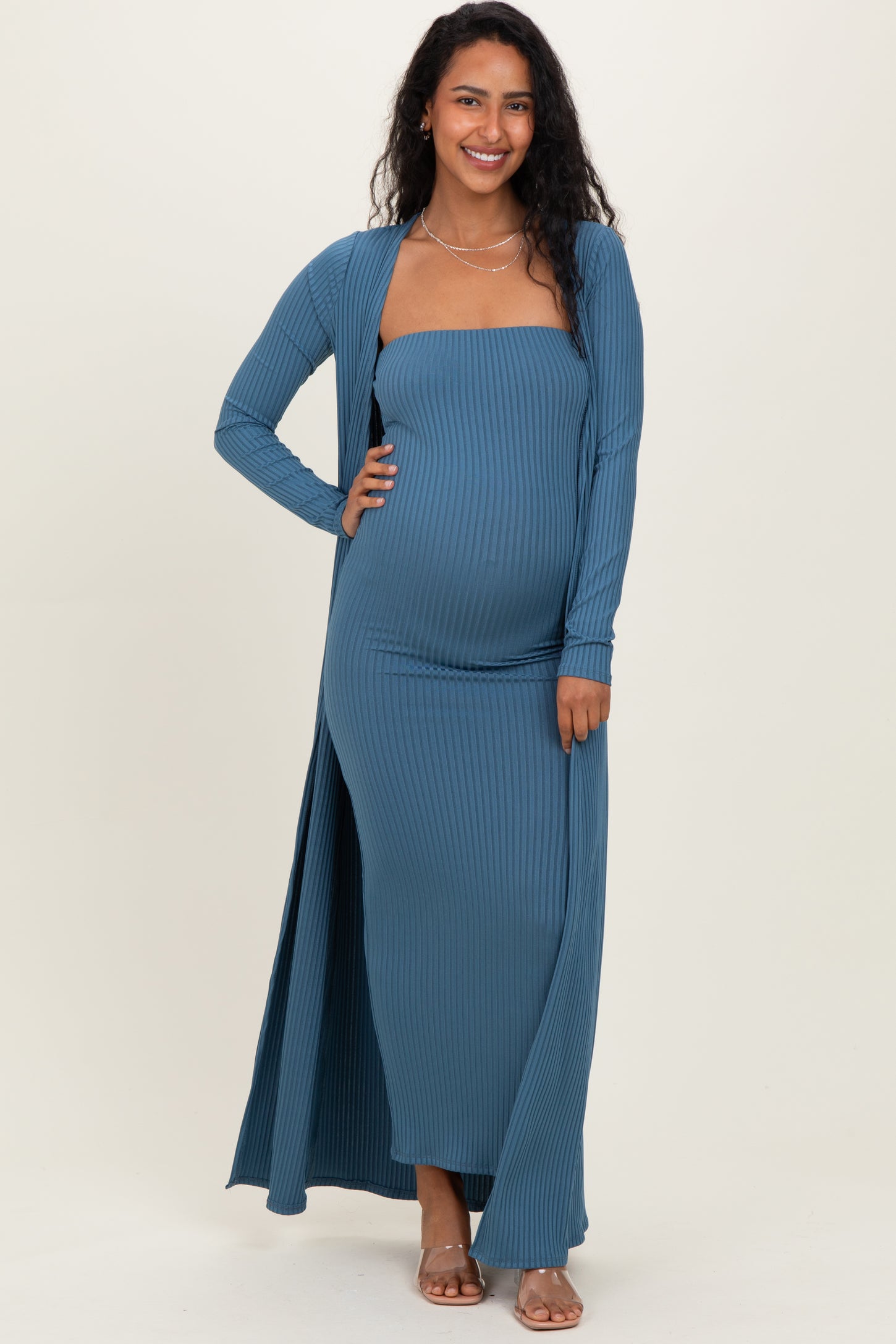 woman wearing a teal ribbed maternity maxi dress with a long cardigan and showing her baby bump