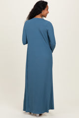 woman wearing a teal ribbed long sleeve maternity maxi dress, shown from the back