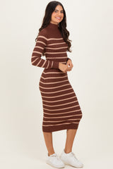woman wearing a brown and tan striped knit midi dress with a mock neckline and long sleeves, standing stylishly