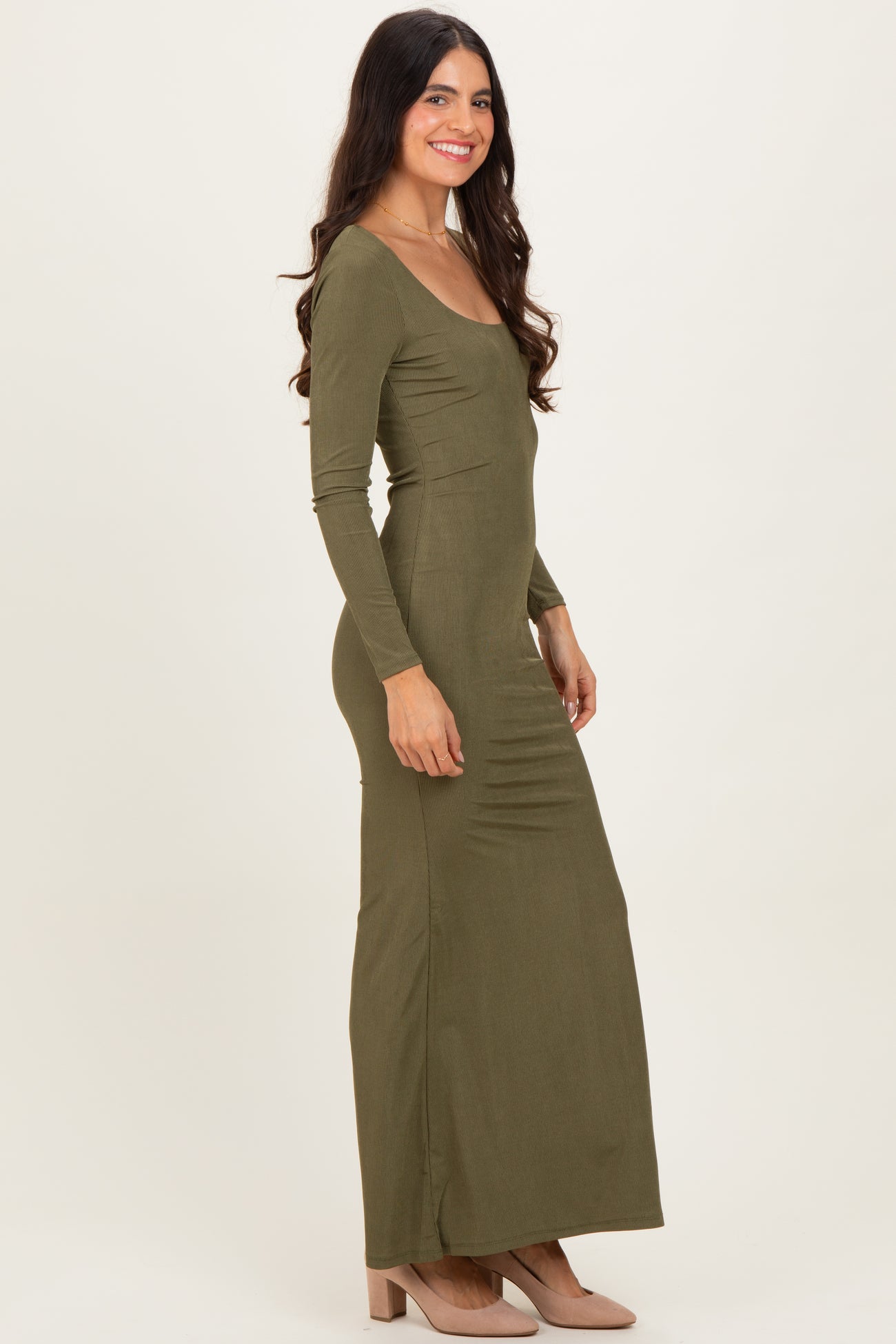 woman wearing a long sleeve olive green maxi dress with a fitted silhouette and side gathering