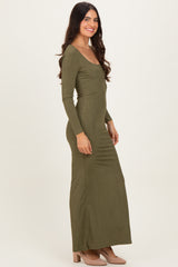 woman wearing a long sleeve olive green maxi dress with a fitted silhouette and side gathering