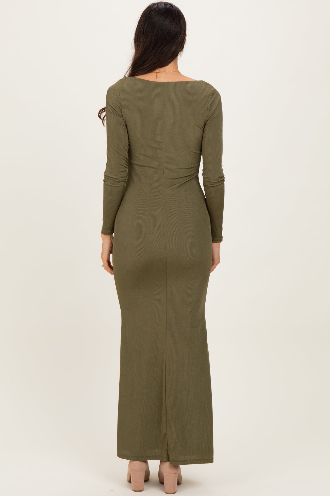 woman wearing a fitted olive green long sleeve maxi dress with a back slit