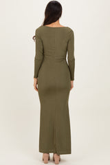 woman wearing a fitted olive green long sleeve maxi dress with a back slit