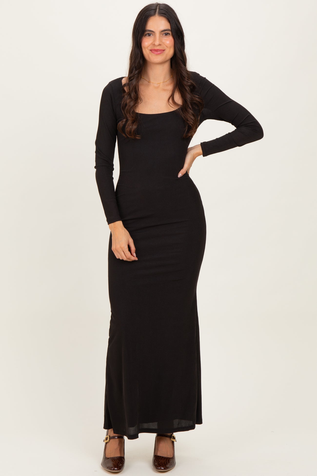 woman wearing a long black fitted maxi dress with long sleeves and a square neckline