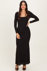 woman wearing a long black fitted maxi dress with long sleeves and a square neckline