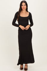 woman wearing a black long sleeve maxi dress with a square neckline and fitted silhouette