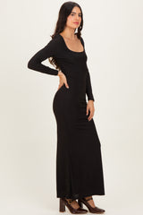 woman wearing a black long sleeve maxi dress with a scoop neckline and side slit