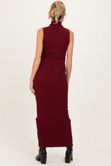 woman wearing a burgundy ribbed maternity maxi dress with a high neck, shown from the back