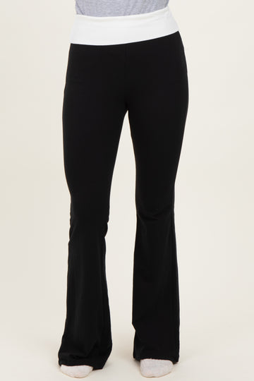 woman wearing black flared yoga pants with a white waistband