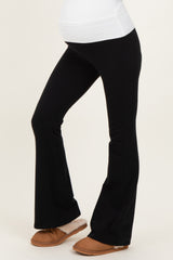 woman wearing black maternity flared pants with a comfortable waistband and a visible baby bump
