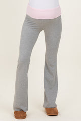 maternity wear gray flared pants with a pink waistband, model is wearing them standing upright