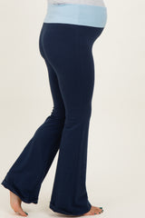 woman wearing navy blue maternity bell-bottom pants with a light blue waistband and a visible baby bump