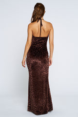 woman wearing a brown velvet leopard print halter maxi dress, shown from the back