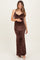woman wearing a brown leopard print maternity maxi dress with a cowl neckline and cradling her baby bump