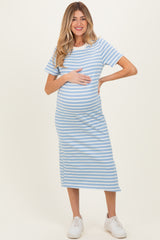 woman wearing a light blue and white striped maternity dress and holding her baby bump