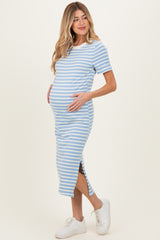 woman wearing a light blue and white striped maternity dress with side slits and holding her baby bump