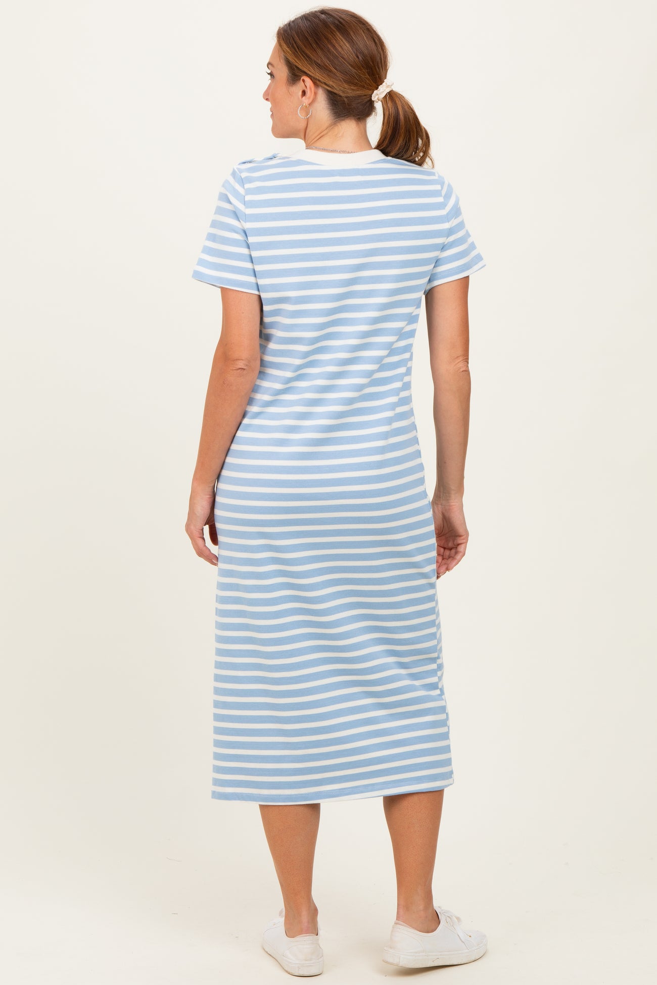 woman wearing a light blue and white striped short sleeve maxi dress, viewed from the back