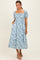 woman wearing a floral print midi dress with a square neckline and puff sleeves, standing with hands in pockets