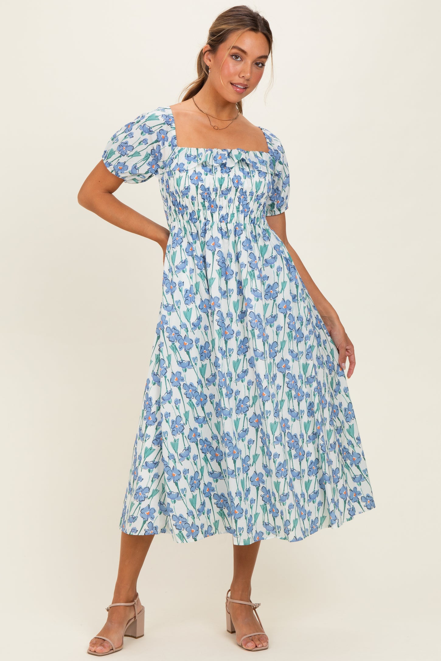 woman wearing a blue and white floral midi dress with puff sleeves and a square neckline