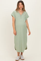 woman wearing a green maternity maxi dress with short sleeves and buttons at the neckline, showing a baby bump