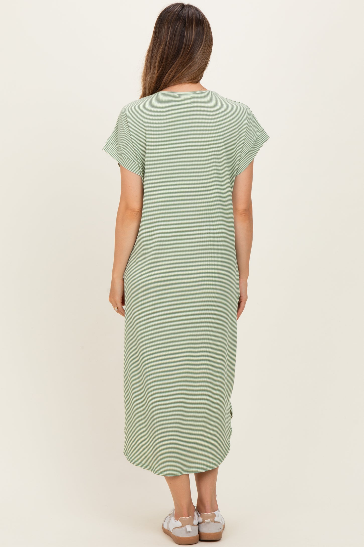 woman wearing a light green maternity maxi dress with short sleeves and side slits, shown from the back