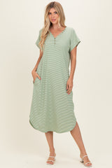 woman wearing a light green short sleeve maxi dress with buttons and side pockets