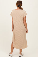 woman wearing a beige short sleeve maxi dress with side slits, shown from the back