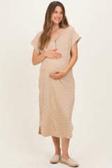 woman wearing a beige short sleeve maternity dress with button details, holding her baby bump