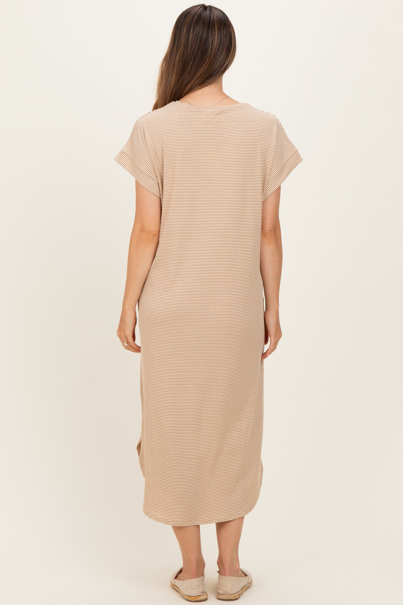 woman wearing a beige maternity wrap dress with short sleeves and side slits, shown from the back