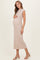 woman wearing a beige ribbed maternity dress and holding her baby bump