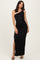 woman wearing a black one-shoulder maxi dress with ruching and a side slit, posing confidently