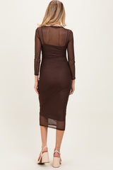woman wearing a sheer brown maternity dress with long sleeves and a form-fitting silhouette, showing a baby bump