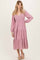 woman wearing a light pink long sleeve tiered maxi dress with a smocked bodice and a v-neckline