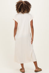 woman wearing a long blush pink maternity dress with short sleeves, seen from the back