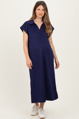 woman wearing a navy blue short sleeve maternity dress with a collared neckline and relaxed fit, showing baby bump