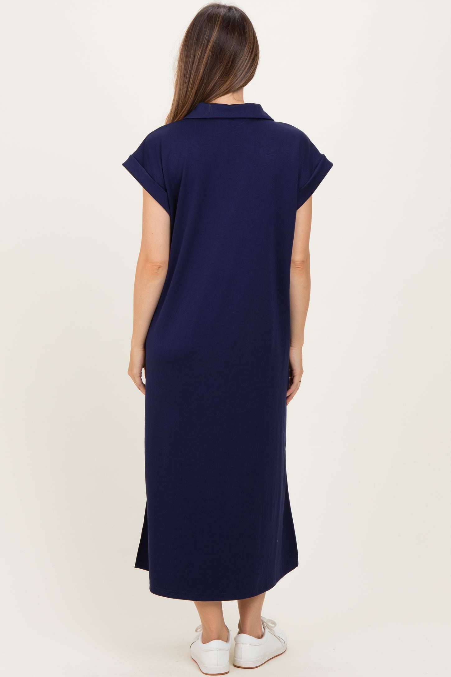 woman wearing a navy blue maternity maxi dress with short rolled sleeves, seen from the back