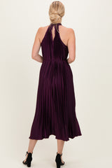 woman wearing a burgundy pleated halter neck midi dress, shown from the back