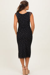 woman wearing a black maternity dress with floral print and a fitted silhouette, seen from the back