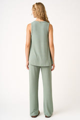 woman wearing a light green sleeveless top and matching wide-leg pants, viewed from the back