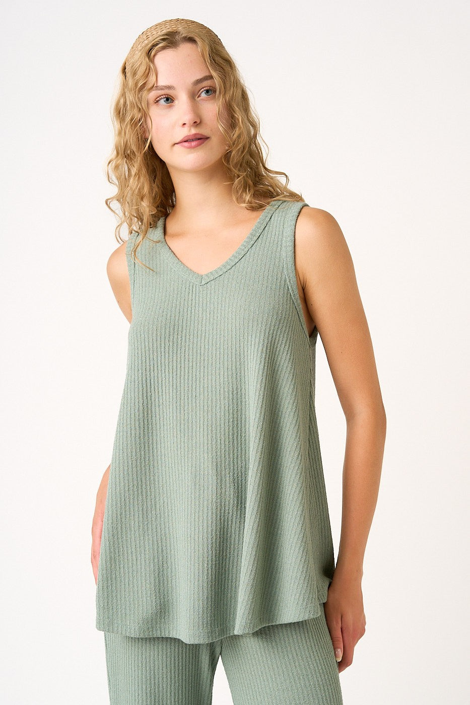 woman wearing a light green sleeveless ribbed top with a v-neckline
