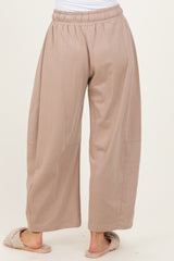 woman wearing beige wide-leg lounge pants with an elastic waistband and side seam details