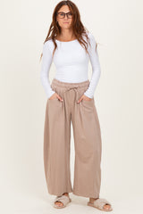 woman wearing a white long sleeve top and beige wide-leg pants with elastic waistband and pockets
