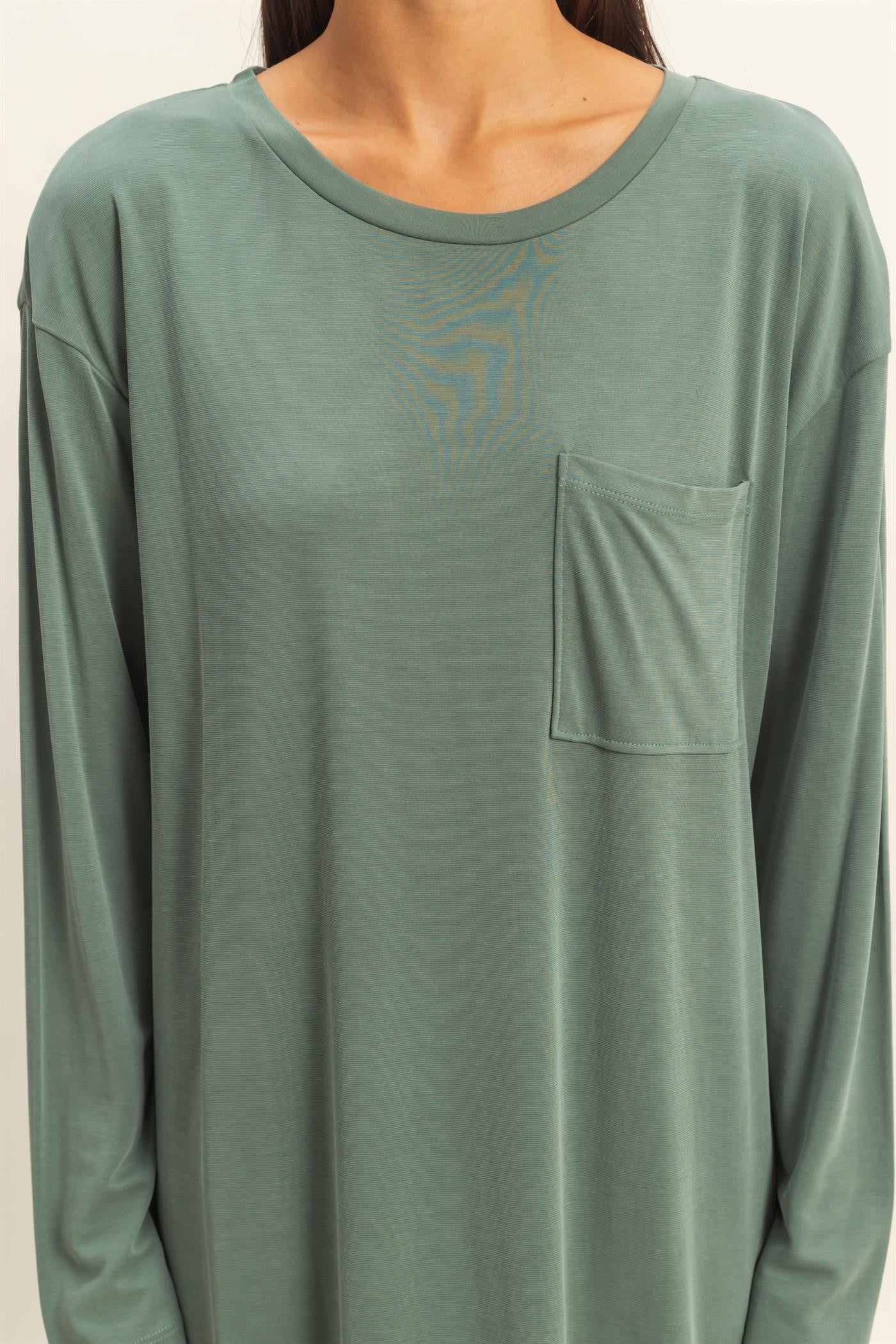 woman wearing a green long sleeve top with a front pocket