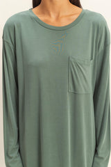 woman wearing a green long sleeve top with a front pocket